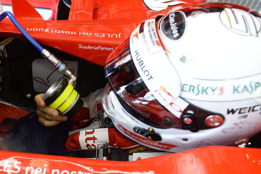 Il caldo si fa sentire anche sulla pista e ai box. Sebastian Vettel si rinfresca con ventilatore e bevande energetiche (Ercole Colombo)